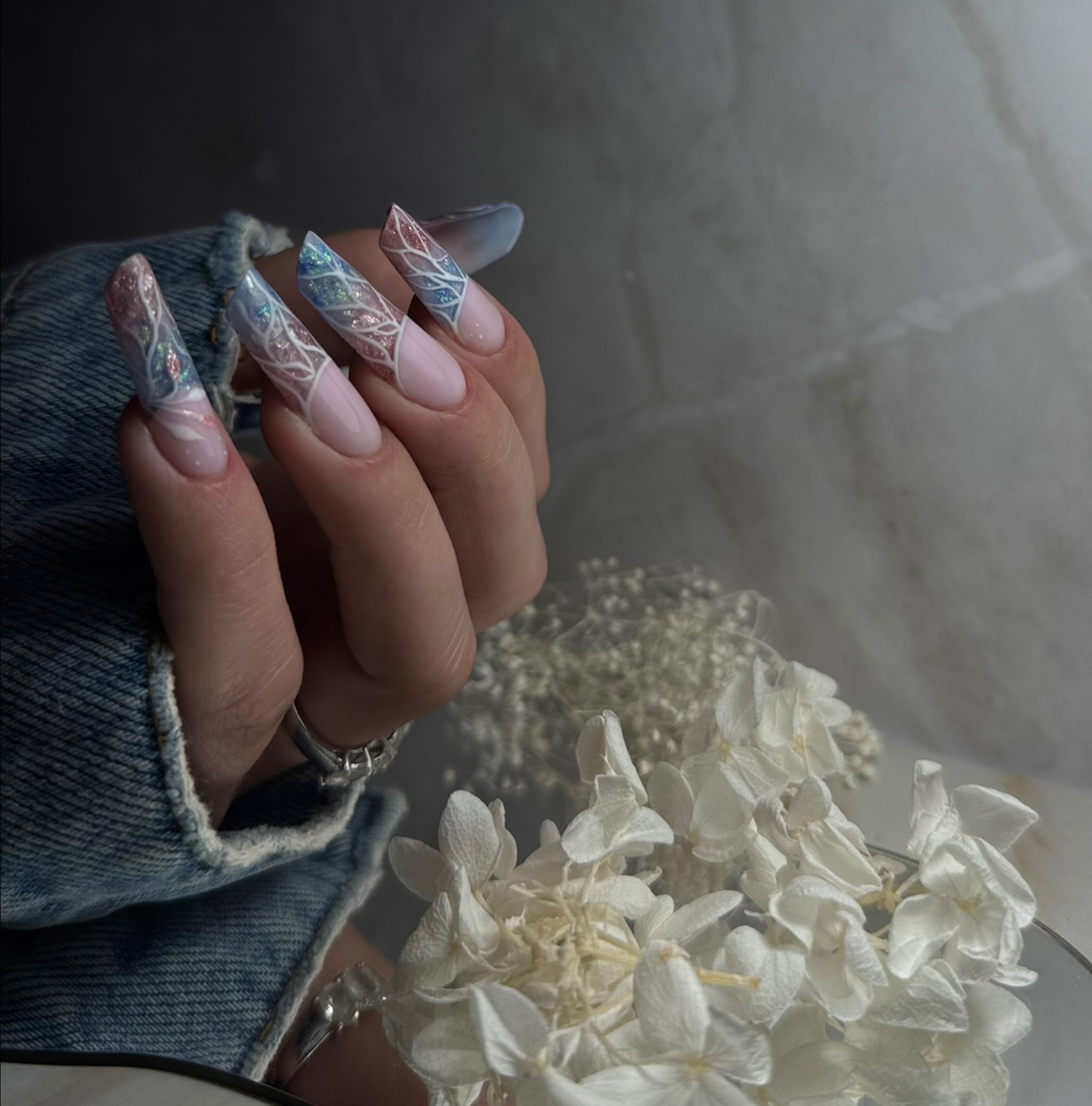 Lange heldere amandelnagels met blauw-witte marmer nail art