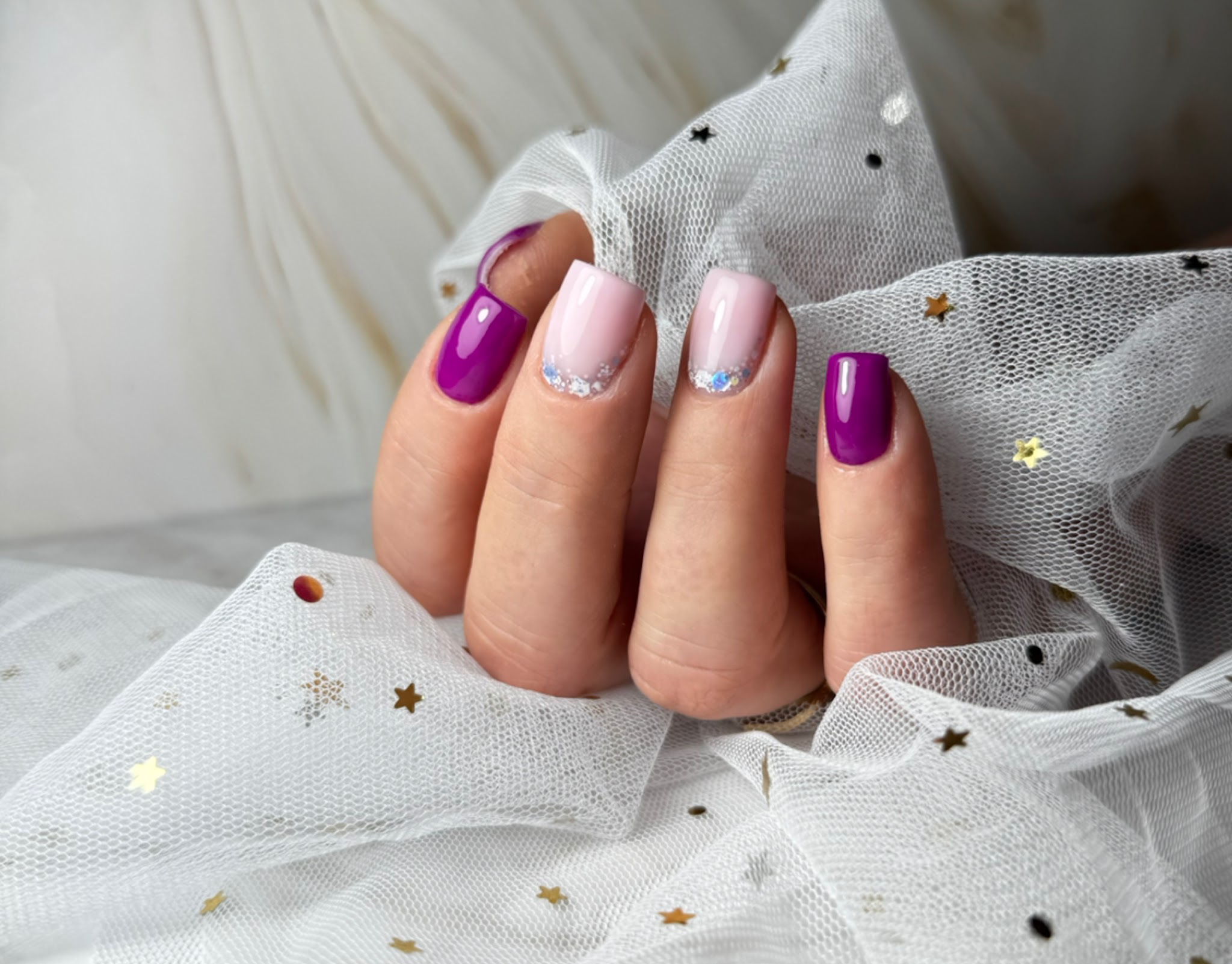 Korte nagels in paars en lichtroze met glitter accenten